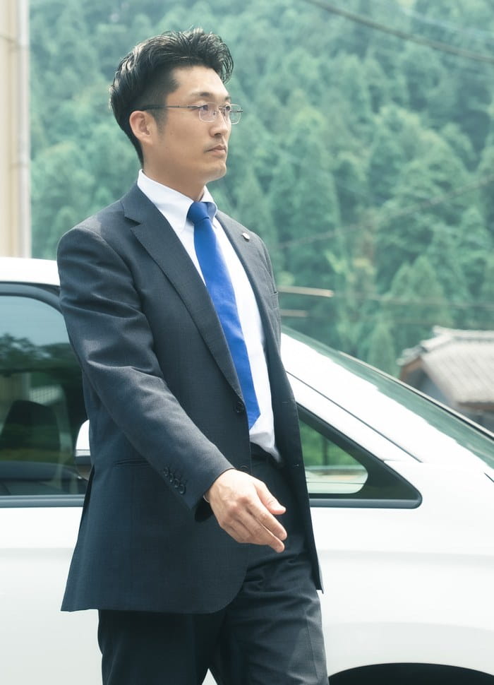 車の前に立つ社員