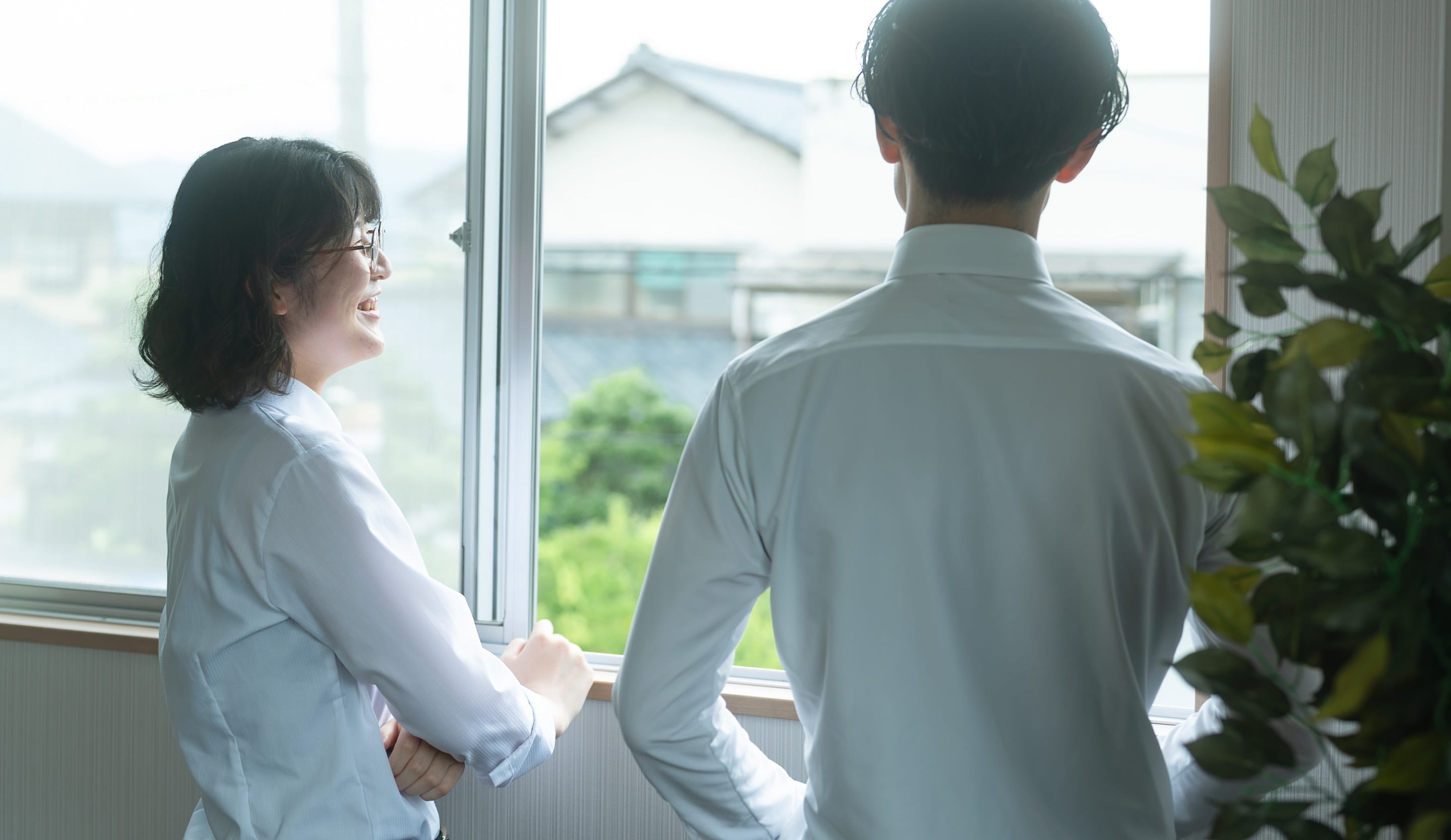 窓辺で立ち話する社員